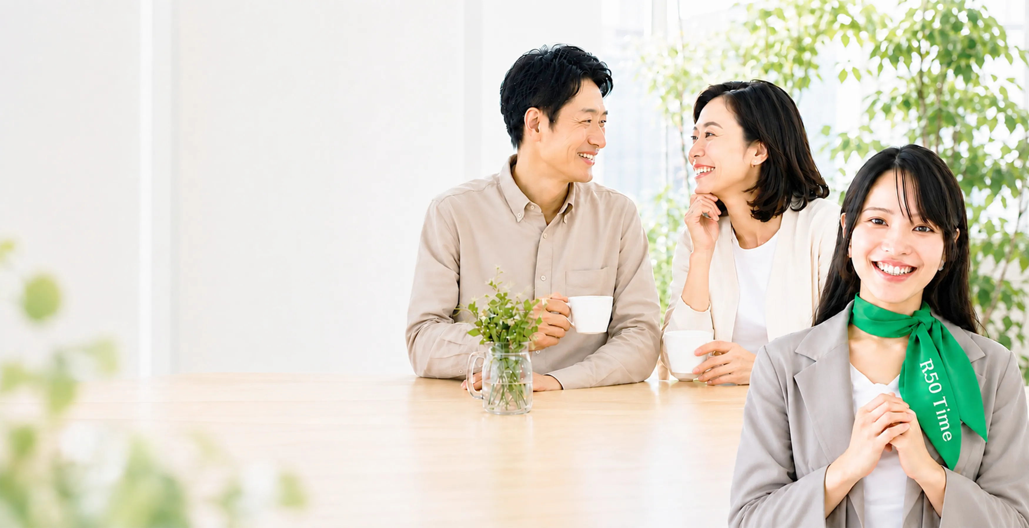 明るい室内で笑顔を交わす大人世代の男女と、R50Time運営責任者